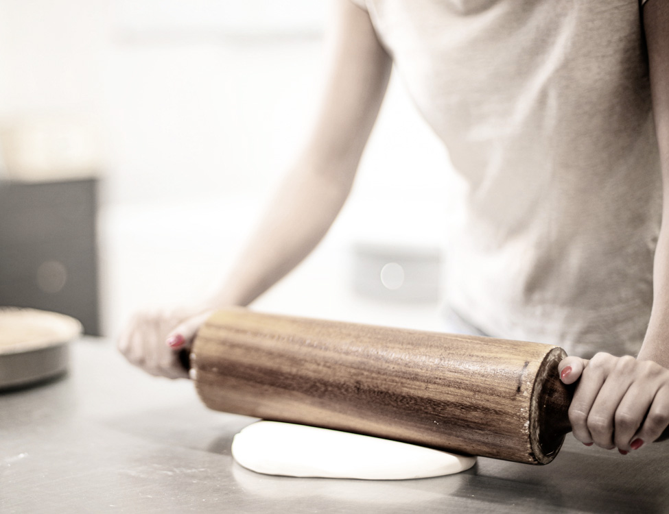 person rolling out pastry