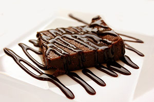 Brownie drizzled with chocolate on a plate